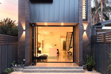 Modelo de fachada de casa gris contemporánea de dos plantas con revestimiento de metal, tejado plano y tejado de metal