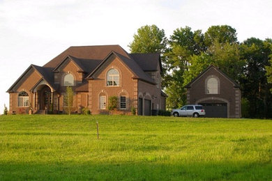 Huge transitional three-story brick exterior home idea in Nashville