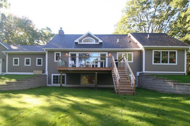 Ejemplo de fachada de casa gris tradicional renovada de tamaño medio de una planta con tejado a dos aguas, revestimiento de madera y tejado de teja de madera