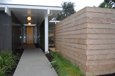 Ejemplo de fachada de casa gris vintage de tamaño medio de una planta con revestimiento de madera y tejado plano