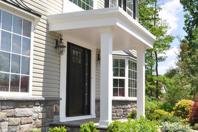 Example of a mid-sized arts and crafts green two-story stone exterior home design in Philadelphia