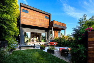 Идея дизайна: двухэтажный, деревянный, разноцветный частный загородный дом среднего размера в стиле модернизм с плоской крышей и зеленой крышей