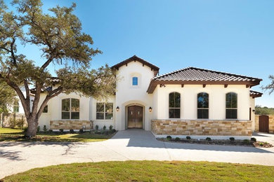 Example of a large tuscan white one-story stucco exterior home design in Austin