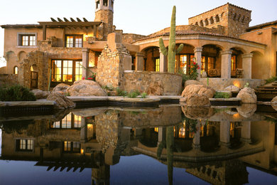 フェニックスにある巨大なサンタフェスタイルのおしゃれな家の外観 (石材サイディング) の写真