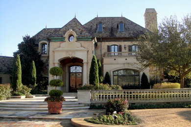 Example of a large classic beige three-story stucco house exterior design in Orange County with a hip roof and a shingle roof