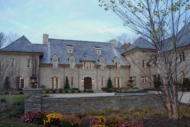 Foto della facciata di una casa classica con rivestimento in mattoni e falda a timpano