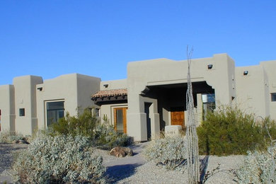 Example of a mid-sized southwest beige one-story adobe flat roof design in Phoenix