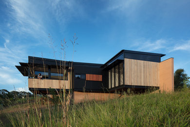 Réalisation d'une petite façade de maison marron design en bois de plain-pied avec un toit en métal.