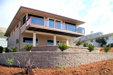 Example of a mid-sized trendy beige two-story stucco exterior home design in San Luis Obispo with a shingle roof