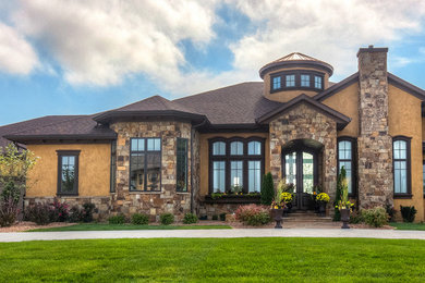 Large elegant beige one-story stone exterior home photo in Cedar Rapids with a hip roof