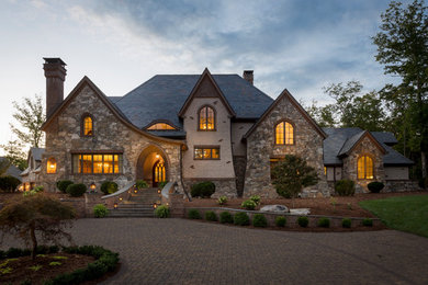 Example of a huge arts and crafts gray two-story stone exterior home design in Other