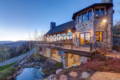 Huge mountain style three-story stone exterior home photo in Denver with a shingle roof
