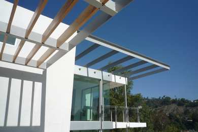 Imagen de fachada de casa blanca minimalista grande de tres plantas con revestimiento de hormigón y tejado plano