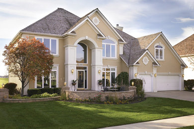 Example of a large classic beige two-story stucco exterior home design in Denver with a shingle roof