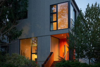 This is an example of a medium sized and gey scandi detached house in Seattle with three floors, wood cladding, a pitched roof and a metal roof.