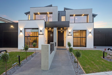 Esempio della facciata di una casa a schiera multicolore contemporanea a due piani di medie dimensioni con rivestimento in metallo, tetto piano e copertura in metallo o lamiera