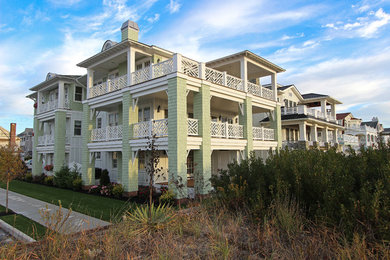 Example of a large beach style green three-story wood exterior home design in Philadelphia