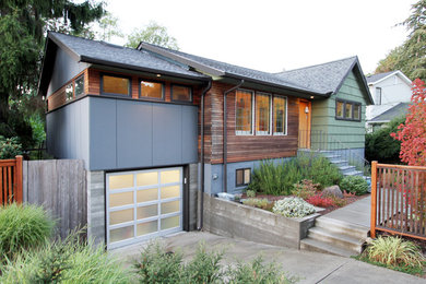 Example of a mid-sized transitional green one-story mixed siding exterior home design in Seattle with a shingle roof