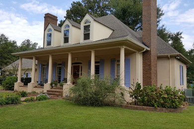 Ejemplo de fachada de casa beige clásica grande de dos plantas con revestimiento de estuco, tejado a cuatro aguas y tejado de teja de madera