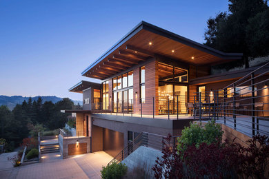 Diseño de fachada de casa beige actual grande de dos plantas con revestimiento de estuco y tejado de metal