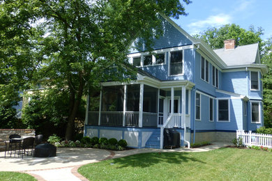 Foto della facciata di una casa grande blu vittoriana a due piani con rivestimento con lastre in cemento