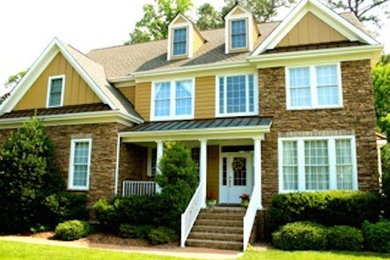 Example of a large beige two-story stone exterior home design in Other