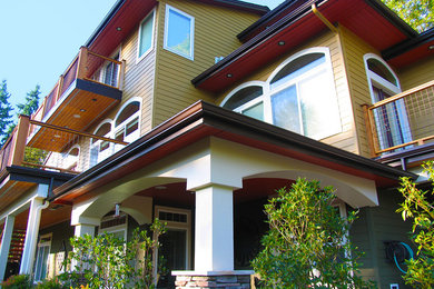 Foto della facciata di una casa grande marrone american style a tre piani con rivestimento in legno e tetto a capanna