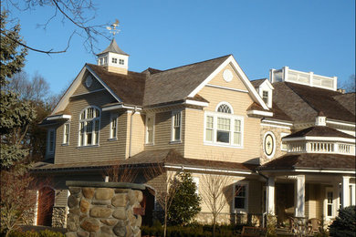 Foto de fachada de casa beige tradicional de tamaño medio de dos plantas con tejado a dos aguas, revestimiento de madera y tejado de teja de madera