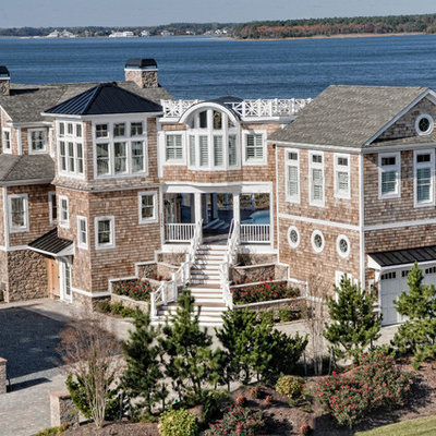Large coastal three-story wood exterior home idea in Other