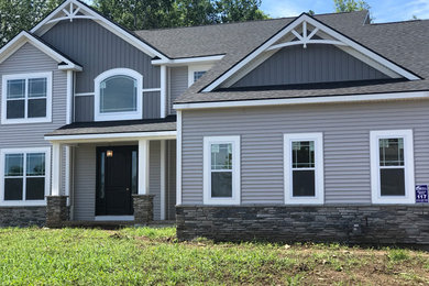 Imagen de fachada de casa multicolor tradicional grande de tres plantas con revestimiento de vinilo, tejado a dos aguas y tejado de teja de madera