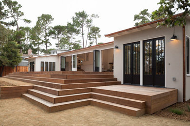 Ejemplo de fachada de casa beige tradicional renovada grande a niveles con revestimiento de estuco, tejado a cuatro aguas y tejado de teja de madera