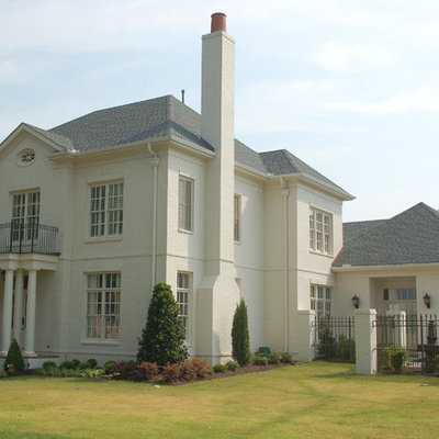 Example of a huge classic white two-story brick house exterior design in Nashville with a clipped gable roof and a shingle roof