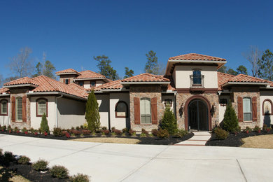 Large traditional beige split-level stucco exterior home idea in Houston