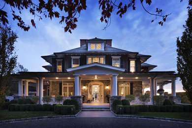 Cette photo montre une très grande façade de maison marron chic à un étage avec un revêtement mixte et un toit à quatre pans.