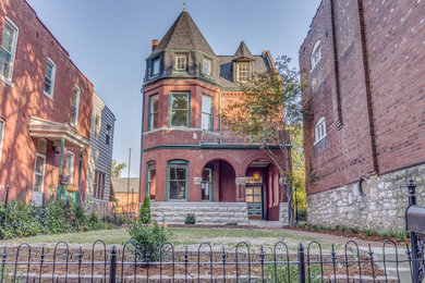 Large ornate red three-story brick house exterior photo in St Louis with a shingle roof