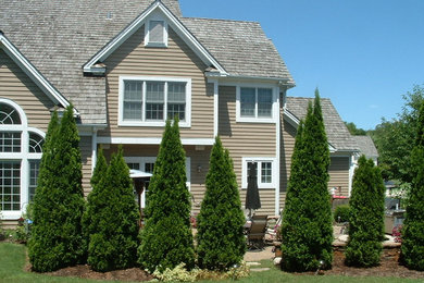 Imagen de fachada marrón tradicional de tamaño medio de dos plantas con revestimiento de vinilo y tejado a dos aguas