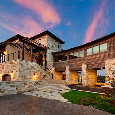 Inspiration for a large mediterranean beige three-story stone exterior home remodel in Austin with a shingle roof