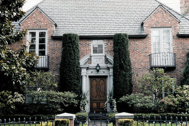 Imagen de fachada roja tradicional renovada de tamaño medio de dos plantas con revestimiento de ladrillo y tejado a la holandesa