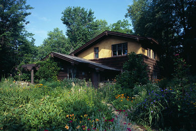 Example of a mid-sized arts and crafts two-story wood and board and batten house exterior design in Other with a shed roof, a shingle roof and a gray roof