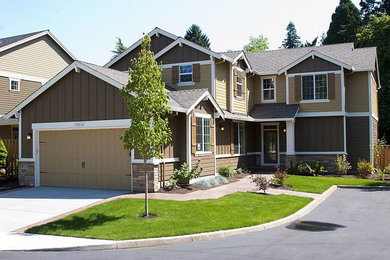 Example of a large brown two-story stone exterior home design in Portland