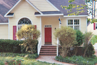 Mid-sized yellow one-story exterior home photo in Raleigh