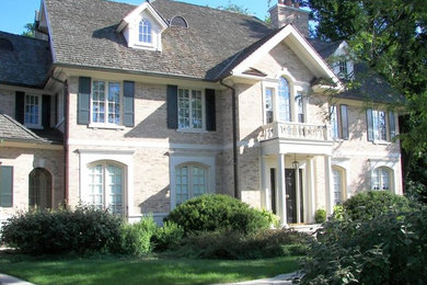 Photo of a large and beige traditional two floor brick house exterior in Chicago.