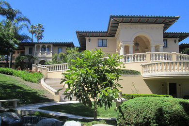 Inspiration for a large mediterranean beige three-story stucco house exterior remodel in Los Angeles