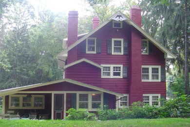 Diseño de fachada roja tradicional de dos plantas con revestimiento de madera