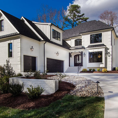 Example of a mid-sized transitional white two-story stucco house exterior design in Raleigh with a mixed material roof