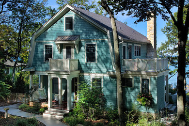 Photo of a blue beach style two floor house exterior in Grand Rapids with wood cladding.