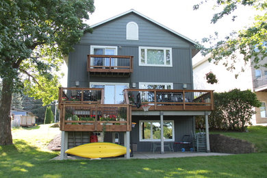 Aménagement d'une grande façade de maison grise campagne en bois à deux étages et plus avec un toit à deux pans.