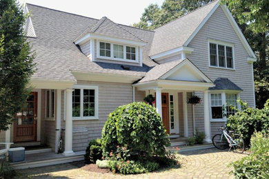Example of a mid-sized classic beige two-story wood exterior home design in Boston with a shingle roof