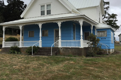 Foto de fachada de casa azul de estilo de casa de campo grande de dos plantas con revestimiento de madera, tejado a doble faldón y tejado de metal