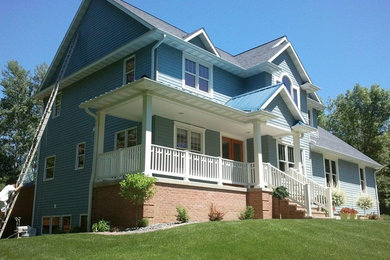 Example of a country blue two-story wood exterior home design in Other